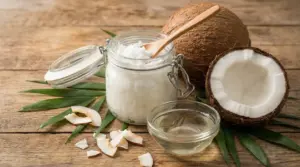 Barattolo con olio di cocco solido, ciotola di olio liquido e cocco su un tavolo di legno